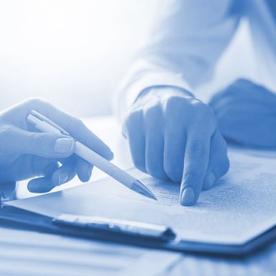 Two people reading a document at a table and highlighting with a pen