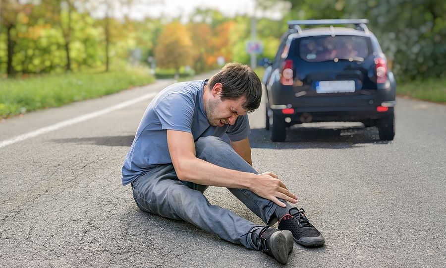 Hit And Run Concept. Injured Man On Road In Front Of A Car.