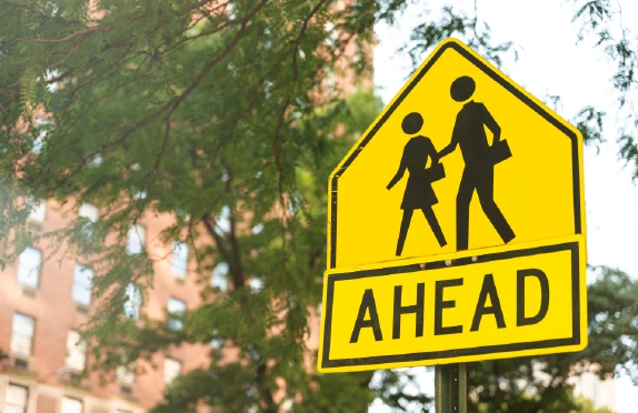 ellow pedestrian crossing warning sign on a city street in Ohio.