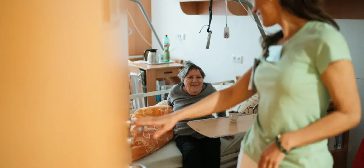 Women in bed in nursing home, getting care